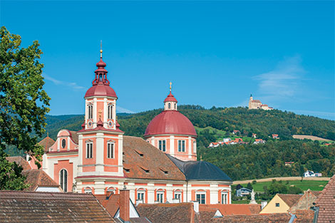 Das Schloss Pöllau mit seinem Kuppeldach - im Hintergrund sieht man den Pöllauberg mit Kirche.