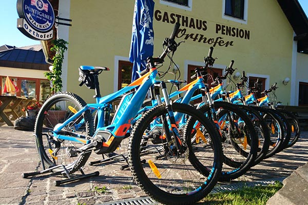 Vor dem Gasthof Orthofer stehen die E-Bikes aufgereiht.